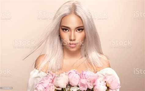 Black Eyed Beautiful Blonde Woman With Oriental Appearance Is Holding