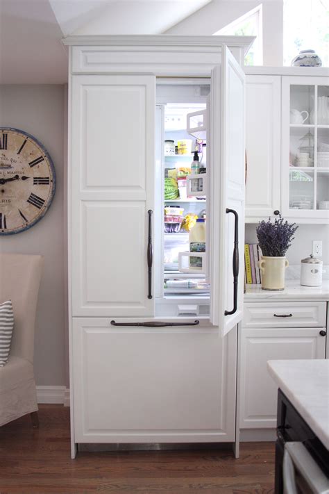 white refrigerator freezer sitting    kitchen    clock   wall