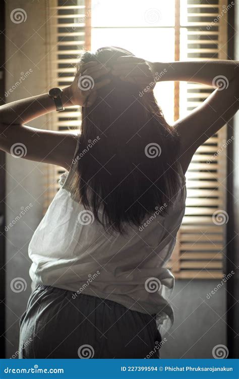 Back Portrait Of Girl Puts Her Hands On The Head With Sunlight And