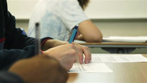 students hands filling  paper form  classroom clipstock