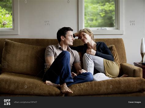 romantic couple talking indoors  sofa stock photo offset