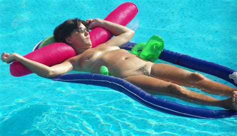 nude wife for all to see and enjoy relaxing on inflatable in pool