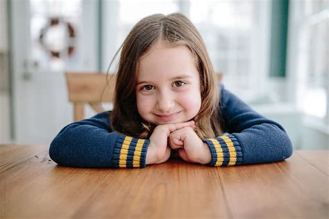 Cute Young Girl Smiling At Table By Stocksy Contributor Jakob