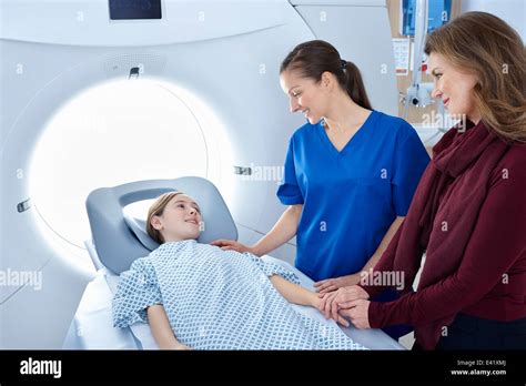 Radiographer And Mother Reassuring Girl Going Into Ct Scanner Stock