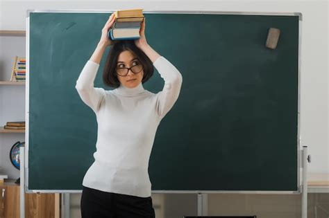 Free Photo Thinking Young Female Teacher Wearing Glasses Holding