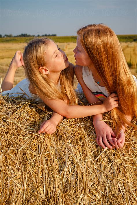 portrait of kissing girls on the hay by stocksy contributor yury