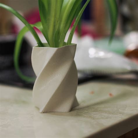 plant   white vase sitting   counter top    computer