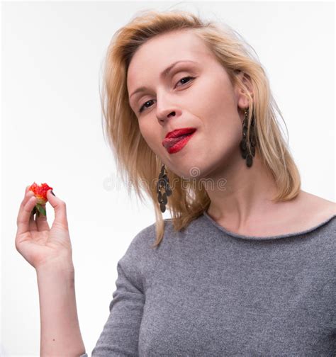 portret van een vrouw die etend aardbeien genieten van stock afbeelding