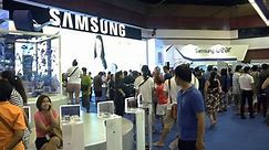 BANGKOK, THAILAND - October 5, 2014: The Samsung Galaxy show and people are walking, Samsung is an Android smartphone produced by Samsung Electronics at Thailand Mobile Expo 2014