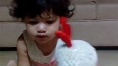 Baby playing with toy rooster