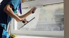 A professional cleaning service worker washes the windows with special foam and cleans them.