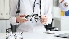 Ophthalmologist optometrist holds glasses for selection of lenses. Myopia farsightedness astigmatism and wearing glasses optics concept