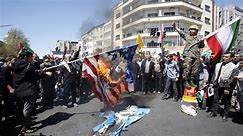 Iranians burn flags & drag coffin as military leader vows to punish West