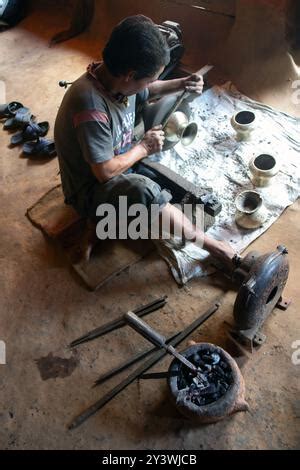 An artisan metal worker heating metal in a forge in his workshop Stock ...