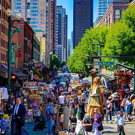 Depict the bustling streets of Seattle, filled with eclectic and eccentric street performers, artists, and vendors.. Image 4 of 4