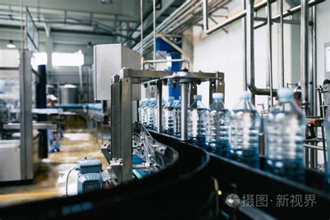 装瓶厂水灌装流水线, 用于加工和装入蓝色瓶子中的纯净泉水。选择性聚焦照片-正版商用图片0rtkd1-摄图新视界