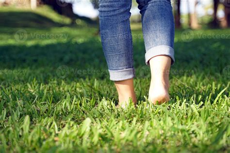 Asian woman walking barefoot on the grass to feel the nature contributes to making people feel ... - is it good to walk barefoot