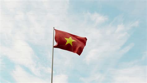 A red flag with a yellow star flying in the sky photo – Flag Image on ...