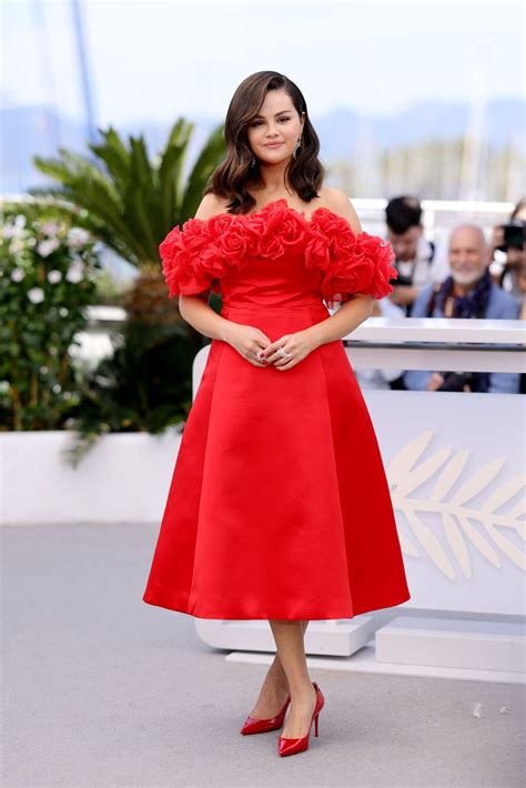 Selena Gomez combina un vestido color rojo con flores 3D con zapatos pumps en la alfombra roja ...