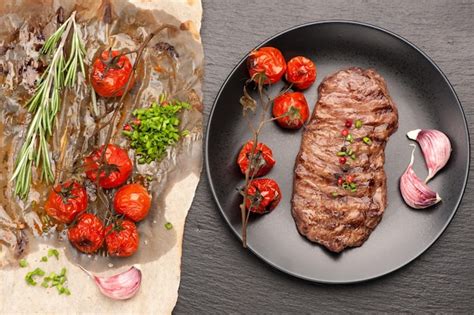 Steak ribeye entrecote and baked tomatoes | Premium Photo