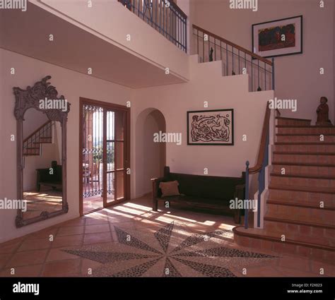 Wooden bench in Spanish villa hall with mosaic patterned floor and a ...