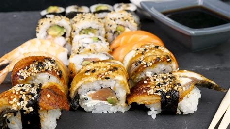 Different sushi rolls on black stone plate. Dolly slide footage ...