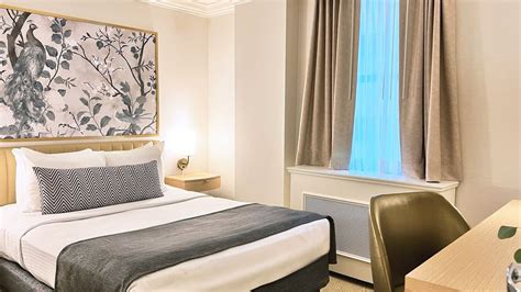 Bed with side tables & work desk near window in Petite Classic at ...
