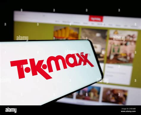 Mobile phone with logo of retail company TK Maxx on screen in front of business website. Focus ...