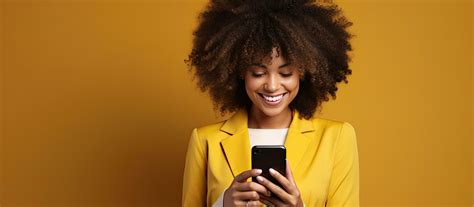 Black woman smiling using phone with yellow background 27184691 Stock ...