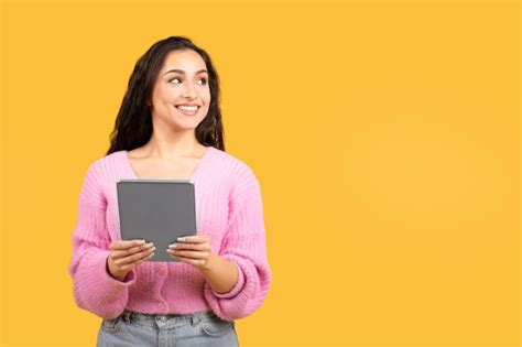 Happy young caucasian brunette woman using tablet looking at empty ...