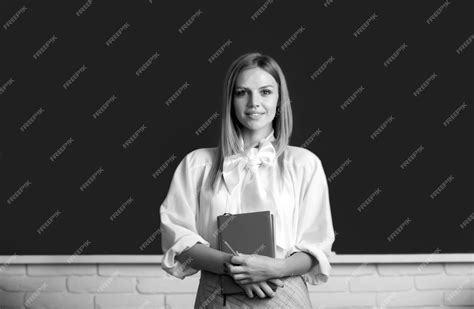 Premium Photo | High school student holding book near blackboard ...