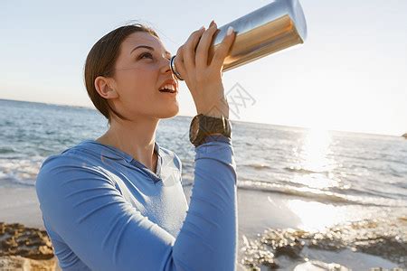 女人海滩上喝水轻女子海滩上锻炼后喝水高清图片下载-正版图片300524443-摄图网