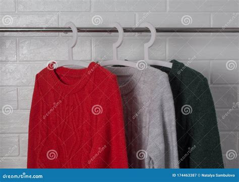 Clothes Hang on Hangers. Sweaters in Red, Green and Melange Colors ...