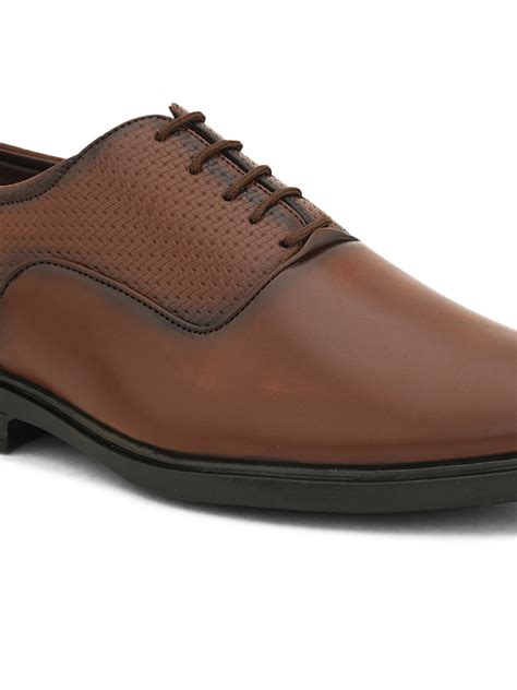 A brown leather dress shoe with laces on a white background.