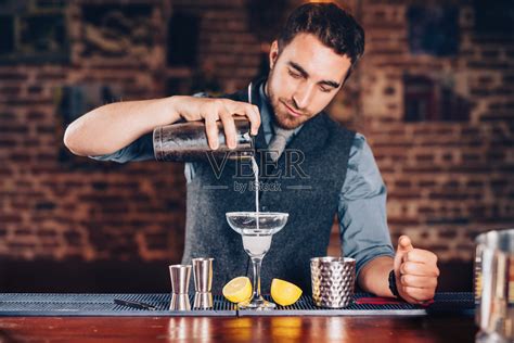专业酒吧服务员准备鸡尾酒饮料,并代表夜生活派活动的高清图片下载-正版图片300715173-摄图网