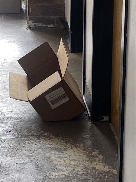 This partially crushed box looks like it’s glitching through the floor. : r/mildlyinteresting