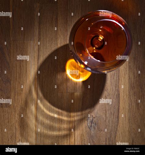 snifter of brandy on a old wooden table Stock Photo - Alamy