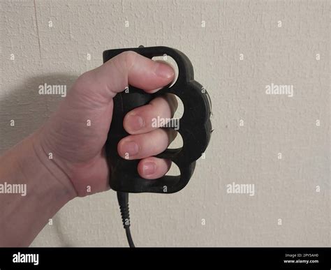 Taser brass knuckles for self-defense and defense Stock Photo - Alamy