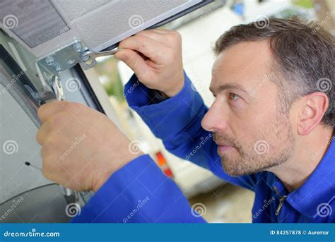 Man installing garage door stock photo. Image of tool - 84257878