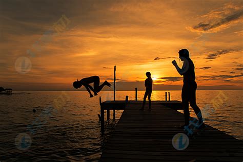 夕阳海边跳水人物身影高清图片下载-找素材