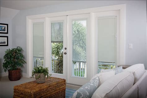 a living room filled with furniture and windows covered in white blinds ...