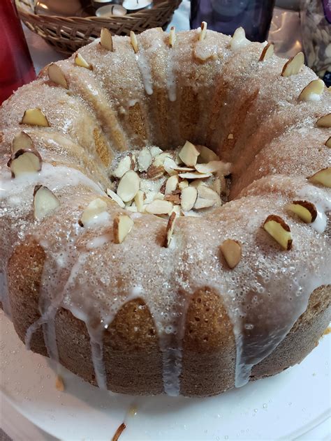 side view of Vaselopita - Greek New Years Cake dusted with powdered sugar with a slice cut out of it