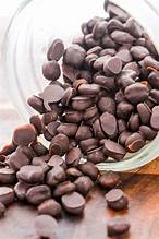 A visual comparison showing coffee cherries on a branch and a split cacao pod revealing cocoa beans inside, highlighting that coffee and chocolate are not made from the same bean.