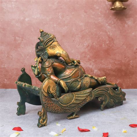 Brass Antique Ganesha resting on peacock couch | The Advitya