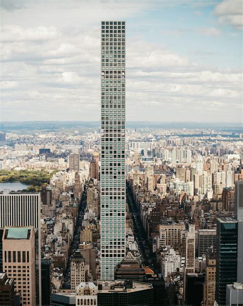 A very tall building towering over a city photo – New york Image on ...