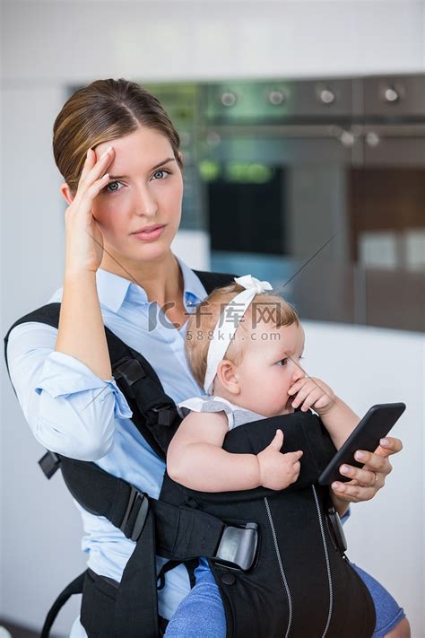 拿着手机的紧张女人带着女婴高清摄影大图-千库网