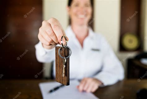 Receptionist handing room key to guest | Premium Photo