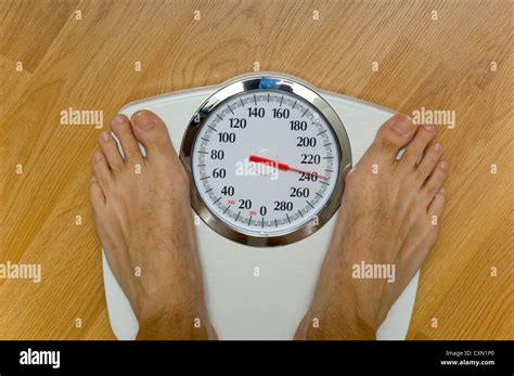 Heavy man on scale with large dial weighing 230 pounds, theme of Stock ...