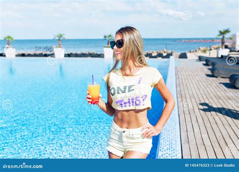 Attractive Blond Girl with Long Hair is Standing Near Pool. she Wears ...
