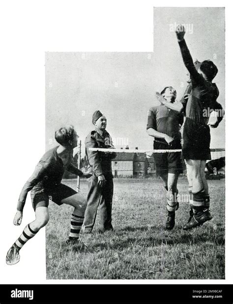 Alex James, in uniform, watches fellow Anti-Aircraft Command members playing football tennis ...